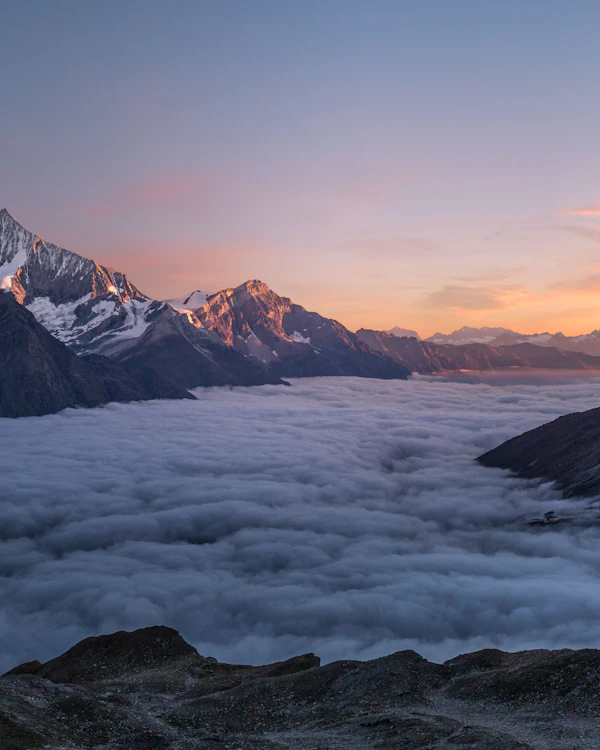Picos de montaña sobresaliendo de un mar de nubes al amanecer