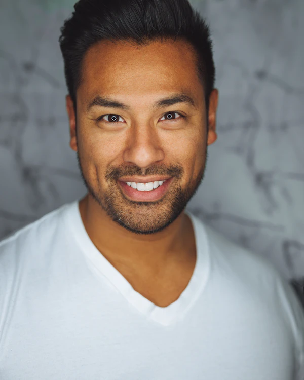Retrato de un hombre sonriendo con playera blanca