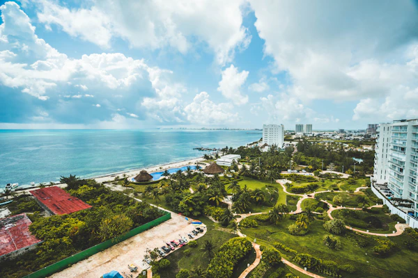 Vista aérea de una costa con hoteles, jardines y el mar al fondo