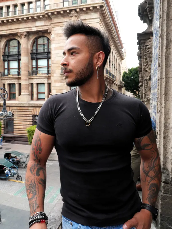 Hombre con playera negra en un balcón frente a edificios históricos del Centro de la Ciudad de México
