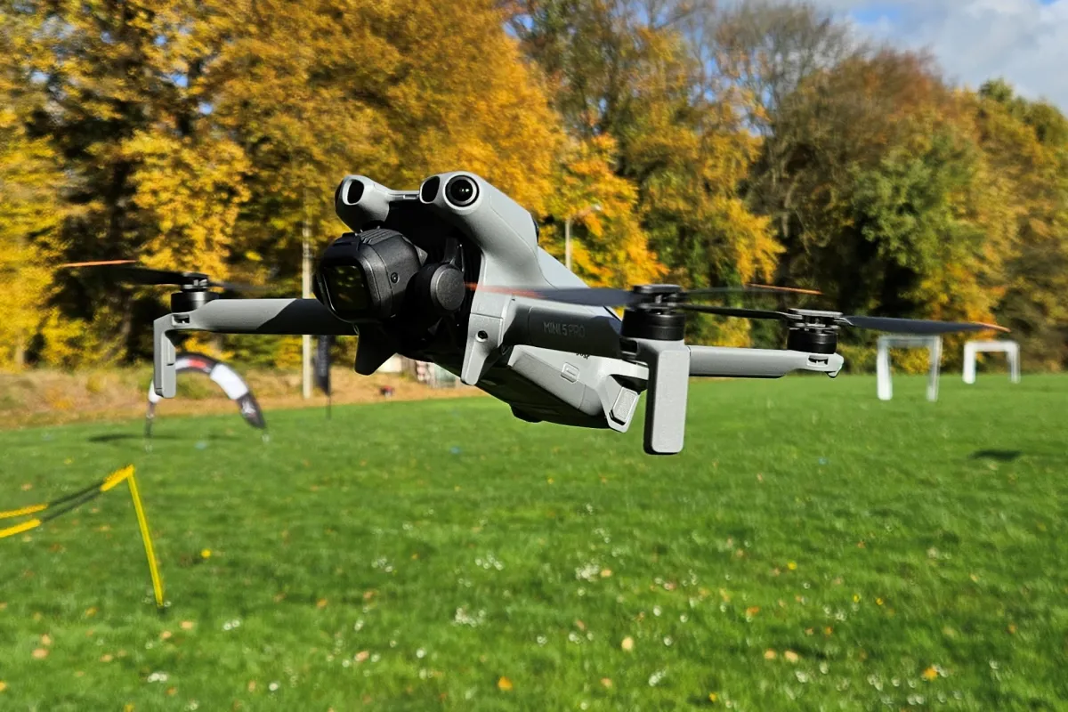 Dron volando sobre un parque, con árboles de otoño al fondo